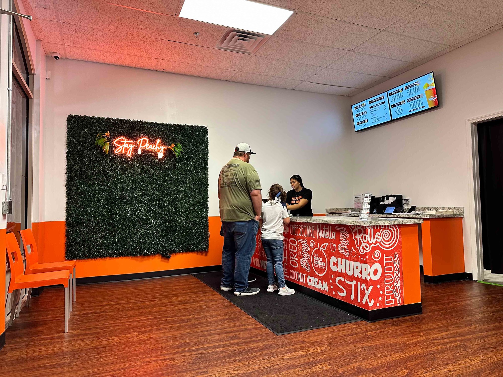 front counter with orange and white walls and greenery backdrop